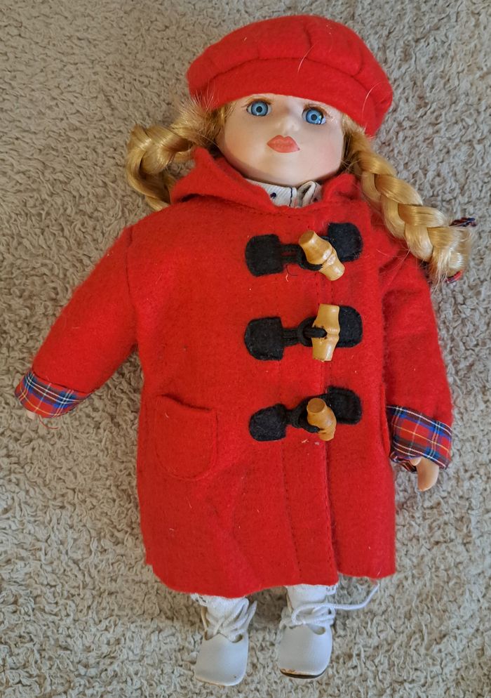 🪆 Poupée en porcelaine - manteau et bonnet rouges