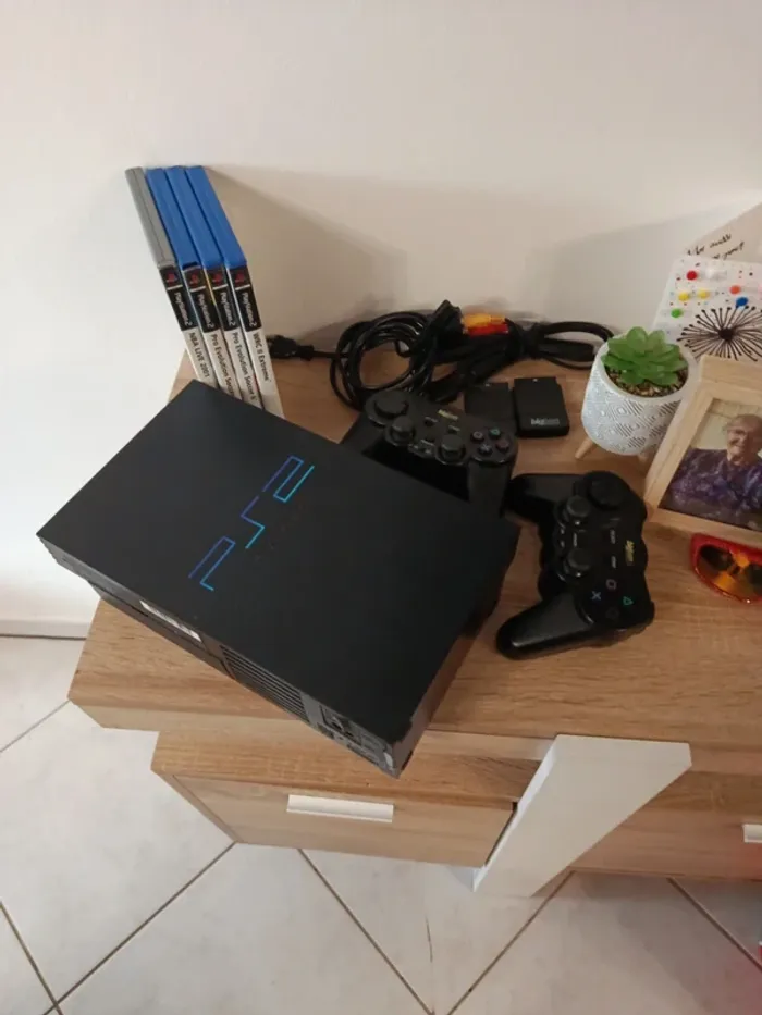 PS2 fat avec 2 manettes et 4 jeux.