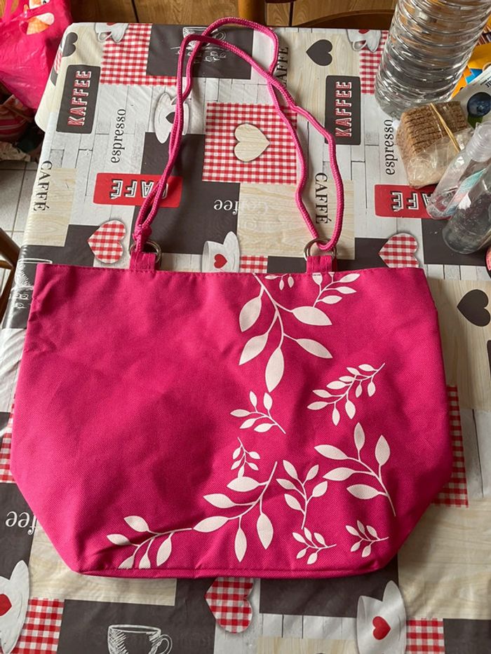 Sac rose à motifs blancs.