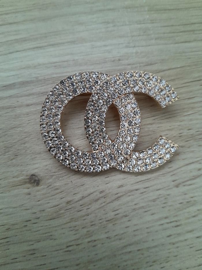 Broche OC, dorée avec strass