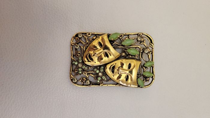 Broche doré visages