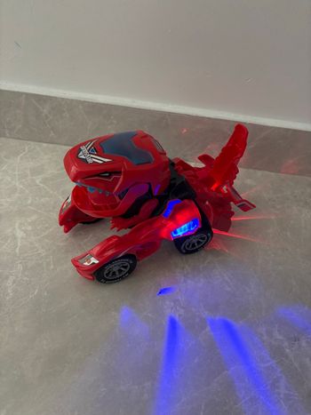Jouet dinosaure /voiture qui se transforme avec sons et lumière avance seule rouge