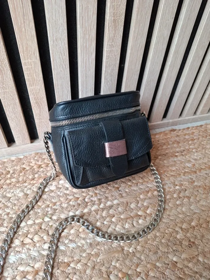 Petit sac noir bandoulière chaîne argentée.