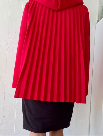 Veste manteau plissée au dos de couleur rouge.