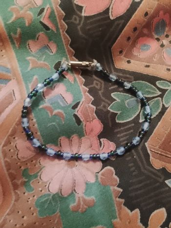 bracelet en perles de plastique bleues claires/bleues foncées.