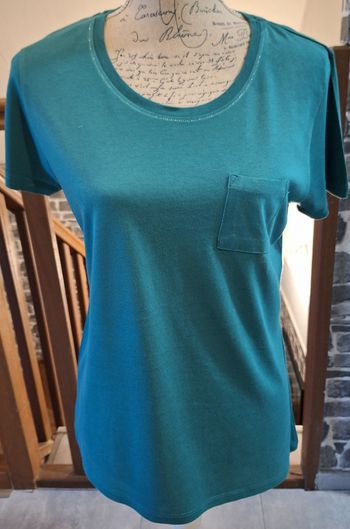 Tee-shirt vert avec un liseré brillant au col et une poche à la poitrine