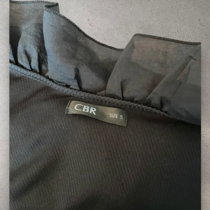 T-shirt haut noir en relief avec froufrou asymétrique très chic et élégant - photo numéro 4