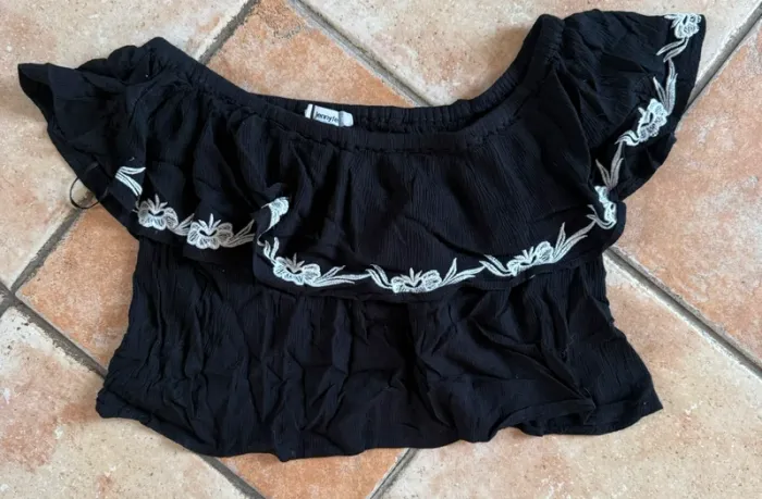 Blouse épaule dénudé taille s Jennyfer à volant noir avec broderie blanche