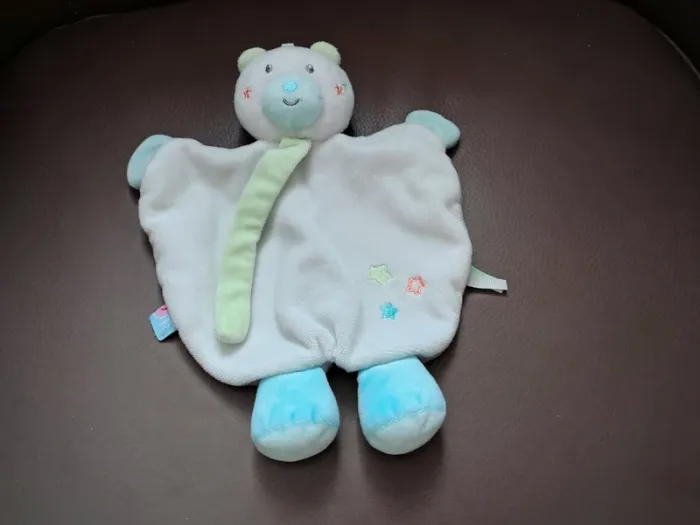 Ours sucre d orge doudou "Doumou"
plat
blanc
étoiles brodées
pattes bleues
attache tétine vert