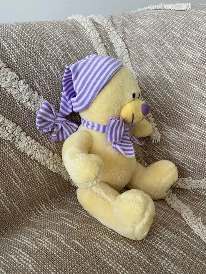 Peluche doudou 28cm ours jaune à fleur violette marguerite très bon état - photo numéro 2