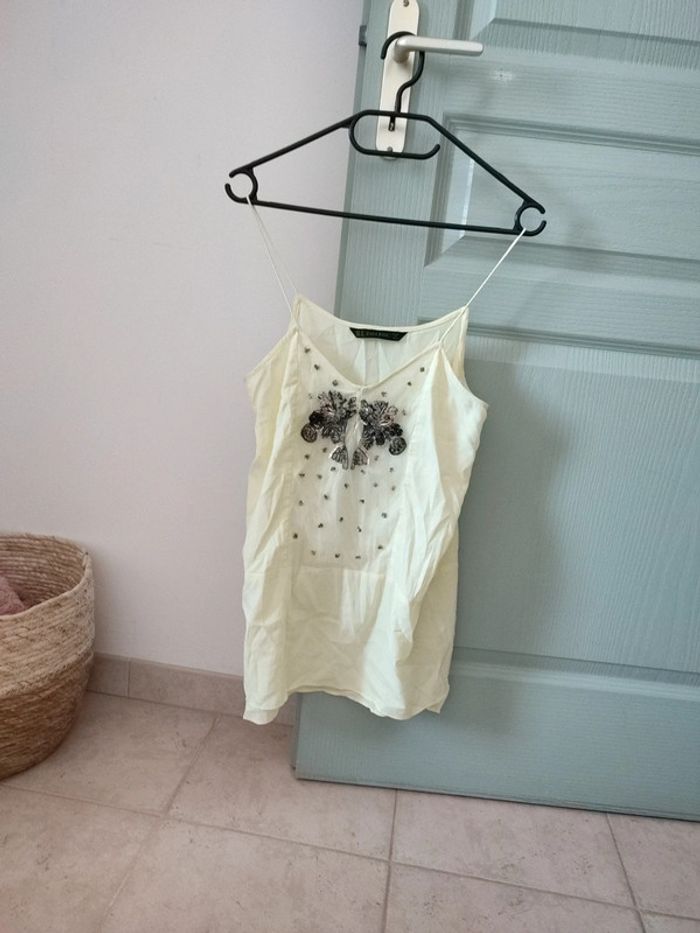 Blouse fines bretelles jaune pâle, ornée d'un bijou