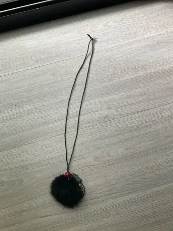 Collier pompon noir et plume
