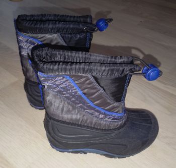 Bottes de ski après-ski bleu marine avec fermeture éclair sur le devant pour mieux les enfiler et lien de serrage 
P. 25-26