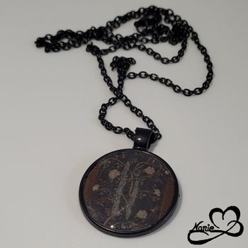 Sautoir, en acier inoxydable et en resine, noir avec des branches et des fleurs.