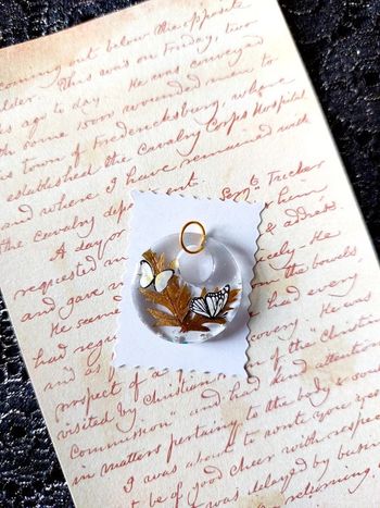 magnifique pendentif en résine avec petits papillons blanc et noir