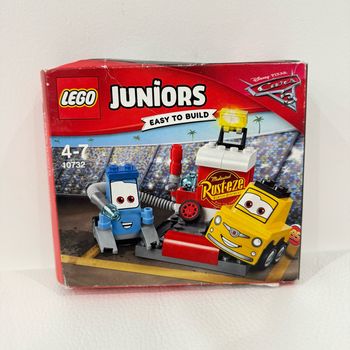 Lego Juniors 10732 - L'arrêt Au Stand De Guido Et Luigi - Boite neuve, scellée mais un peu abîmée (voir photos).