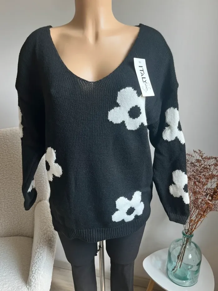Pull noir avec marguerites blanches